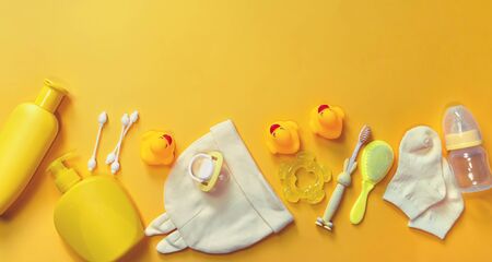 Accessories for bathing newborns on a yellow background. Selective focus. Baby.の写真素材