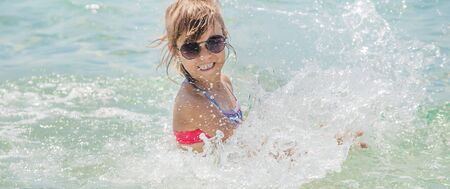 child makes spray on the sea. Selective focus.