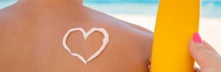 The girl on the beach applies sunscreen to the skin of a man. Selective focus. nature.の写真素材