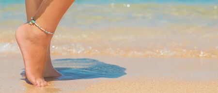 legs of a girl on the seashore. Selective focus. nature.