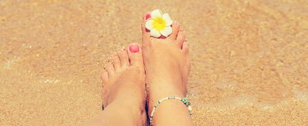 legs of a girl on the seashore. Selective focus. nature.