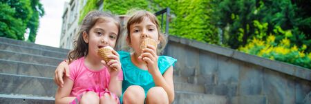 Children eat ice cream in the park. Selective focus.
