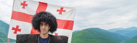 Georgian man in a beech costume on a background of mountains. Selective focus.の写真素材