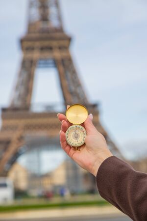 Girl with a compass in hands near the Eiffel Tower in Paris. Selective focus. nature.