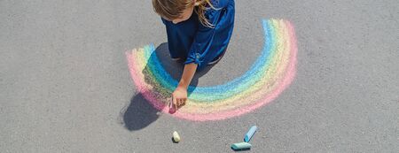child draws with chalk on the pavement. Selective focus.の写真素材