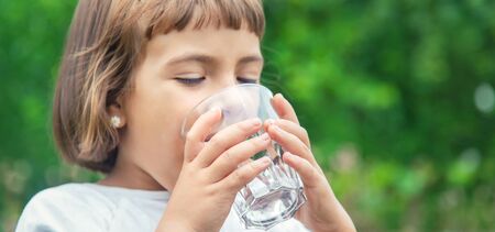 child drinks water from a glass. Selective focus.の写真素材