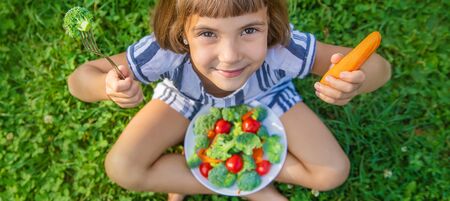 child eats vegetables broccoli and carrots. Selective focus.の写真素材
