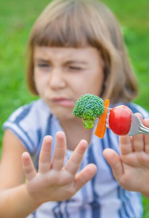 child eats vegetables broccoli and carrots. Selective focus.の写真素材