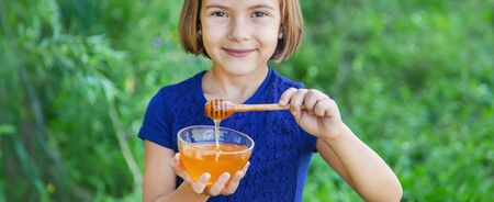 Child a plate of honey in the hands. Selective focus.の写真素材