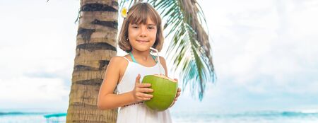 A child on the beach drinks coconut. Selective focus.の写真素材