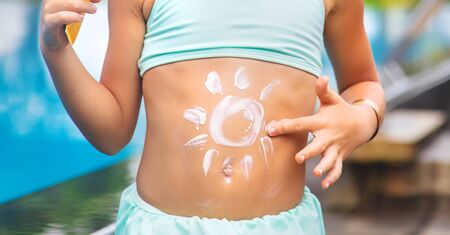 Child on the beach with sunscreen on his back. Selective focus.の写真素材