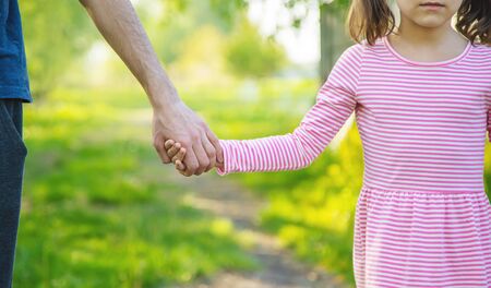 A child with his father goes by the hand. Selective focus. nature.の写真素材