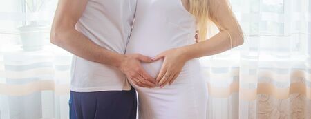 A pregnant woman and a father of a child hug a belly. Selective focus. NATURE.の写真素材