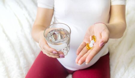 A pregnant woman drinks vitamins. Selective Focus. people.の写真素材