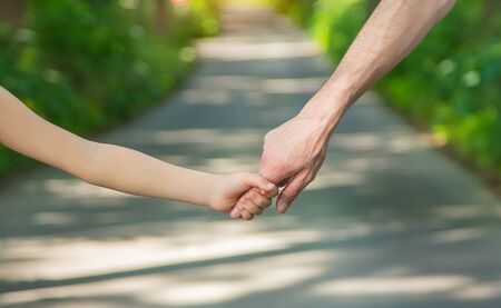 Father and child go holding hand. Selective focus. nature.