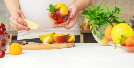 A pregnant woman eats fruit. Selective focus. food.の写真素材