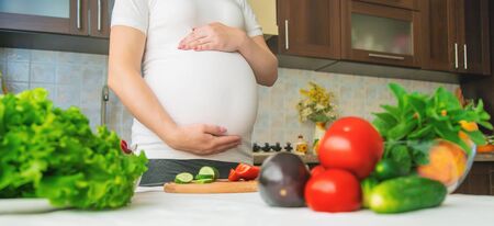 A pregnant woman eats vegetables and fruits. Selective focus. Food.の写真素材