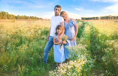 pregnant woman with family outdoors in the field. Selective focus. nature.の写真素材