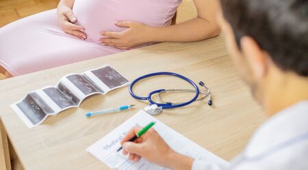 A doctor in a clinic examines a pregnant woman. Selective focus. People.の写真素材
