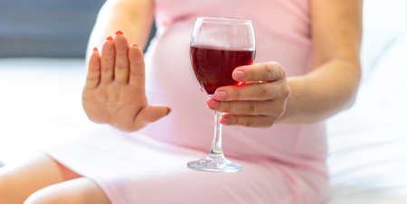 A pregnant woman is drinking wine. Selective focus. people.の写真素材