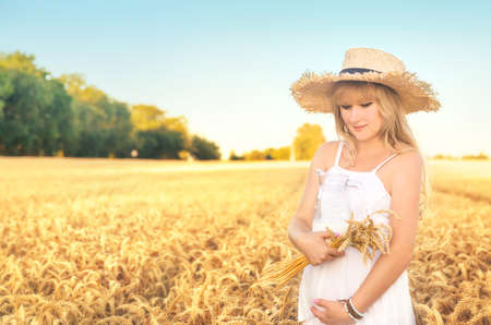 Pregnant woman in a wheat field with milk. Selective focus. nature.