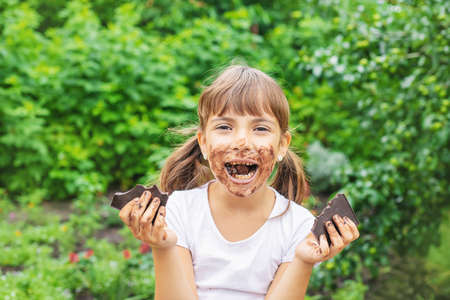 The child eats a chocolate bar. Selective focus. People.の写真素材