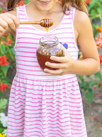 Child eats honey summer photo. Selective focus. nature.