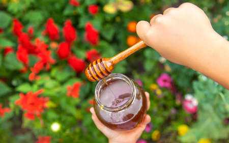 Child eats honey summer photo. Selective focus. nature.