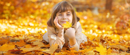 Children in the park with autumn leaves. Selective focus.の写真素材