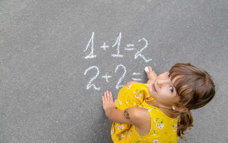 The child writes math on the pavement. Selective focus. summer.の写真素材