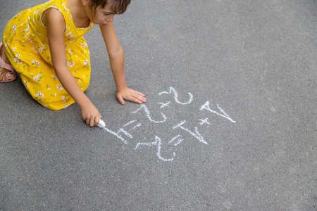 The child writes math on the pavement. Selective focus. summer.の写真素材