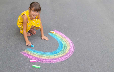 A child draws a rainbow on the asphalt. Selective focus. kid.の写真素材