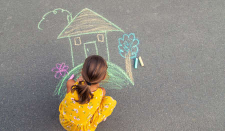 The child draws a house on the asphalt. Selective focus. kid.の写真素材