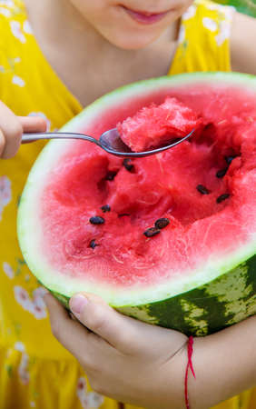 The child eats a watermelon with a spoon. Selective focus. food.の写真素材