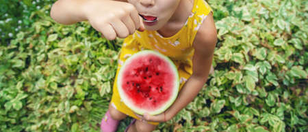 The child eats a watermelon with a spoon. Selective focus. food.の写真素材