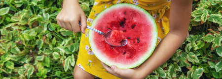 The child eats a watermelon with a spoon. Selective focus. food.
