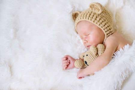 A newborn baby sleeps with a teddy bear. Selective focus. people.の写真素材