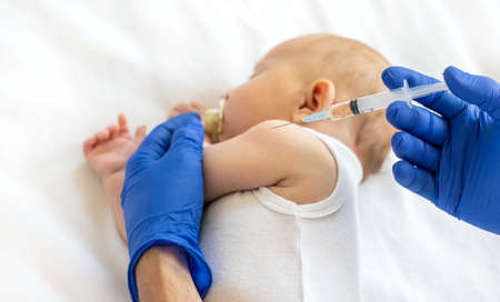 Vaccination baby, injection in the arm. Selective focus. People.