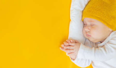 Baby sleeps on a yellow background. Selective focus. People.