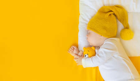 Baby sleeps on a yellow background. Selective focus. People.