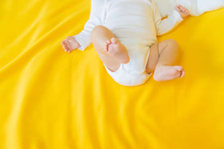 Baby feet on a yellow background. Selective focus. People.の写真素材