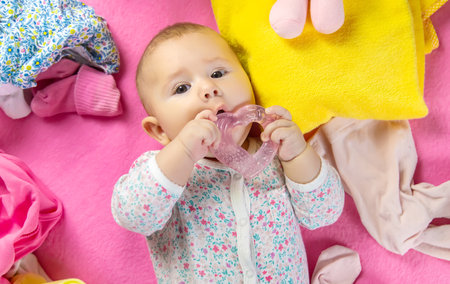 Baby is gnawing on a teether. Selective focus. people.