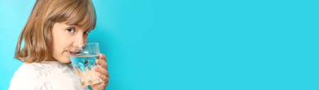 Child girl drinks water from a glass. Selective focus.の写真素材