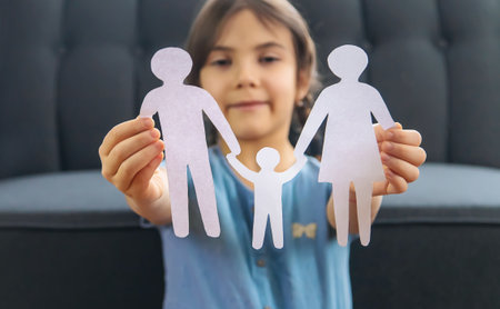 Child with a paper family in his hands. Selective focus. People.の写真素材