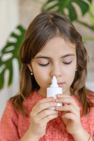 The child drips drops from a cold into his nose. Selective focus. People.の写真素材