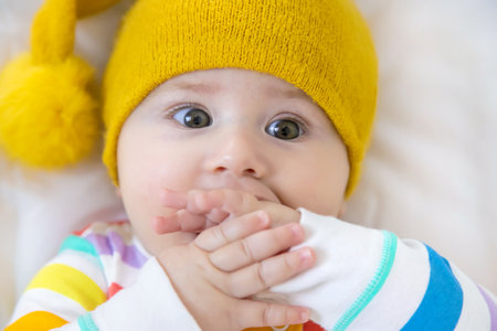 Baby puts his hands in his mouth. Selective focus. People.の写真素材