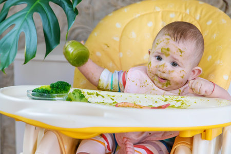 Little baby eats broccoli puree himself. Selective focus. People.の写真素材