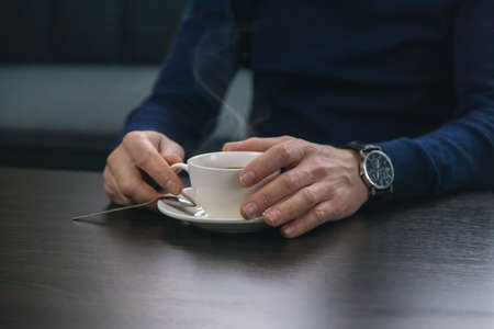 A man at the table with a cup of coffee. Selective focus. Drink.の写真素材
