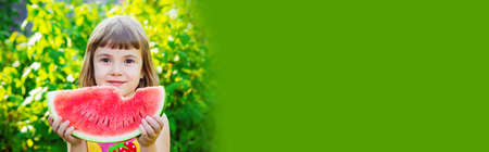 A child eats watermelon. Selective focus. Food nature.の写真素材