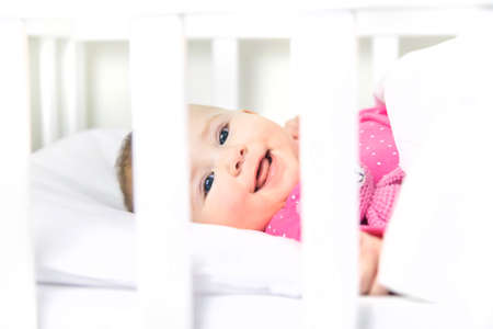 Baby toddler plays in the crib. Selective focus. Child.の写真素材